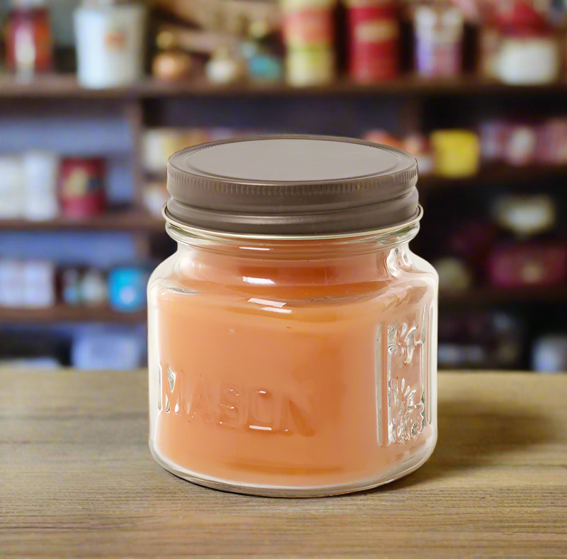 A mason jar candle with a brown lid and a label that reads 'MASON' on the front.