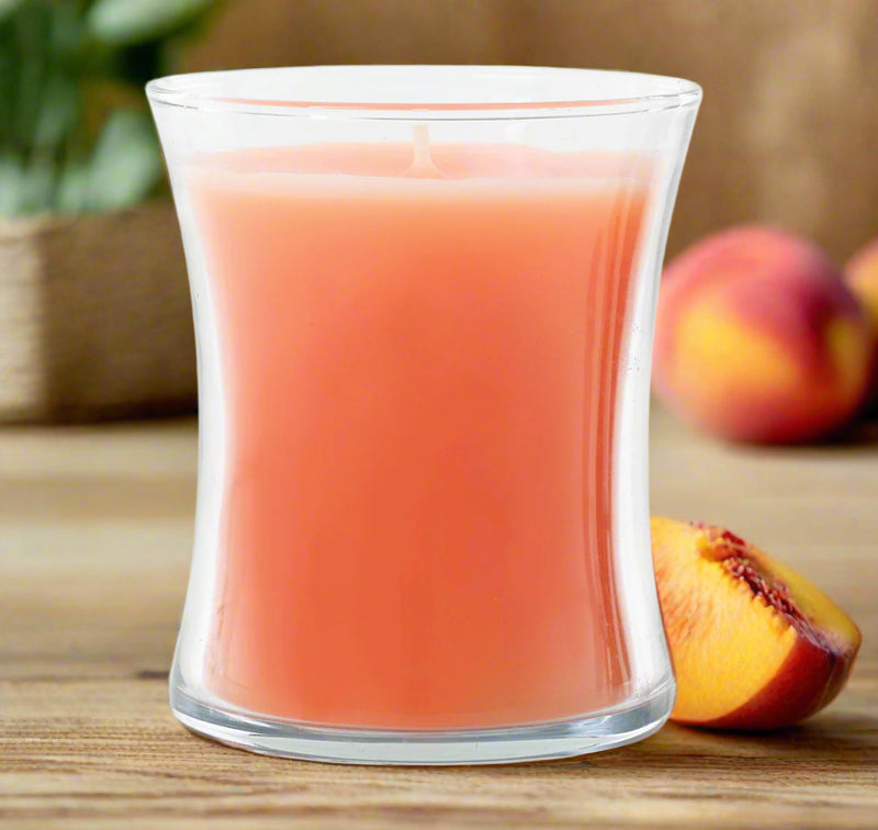 elegant peach Candle in a clear glass container on a white background