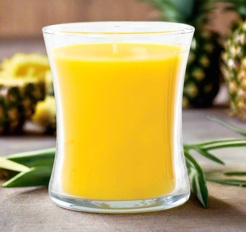 elegant Belize pineapple candle with fresh pineapples in the background