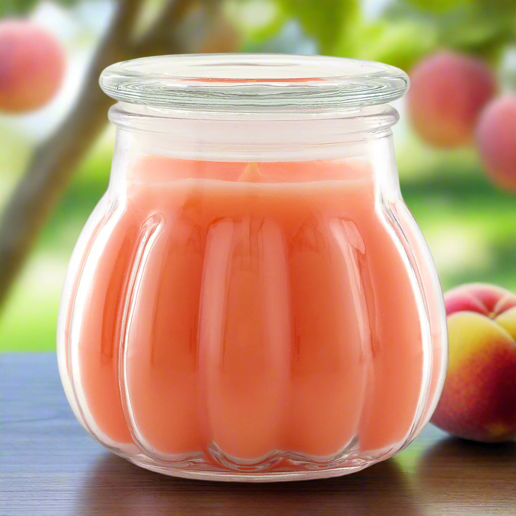 A jar Contempo candle with a peach color scent, contained within a clear glass jar