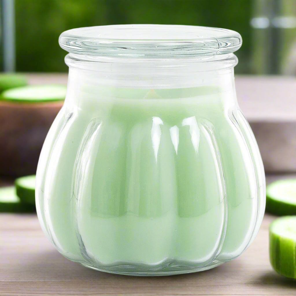 green Contempo candle with a cucumber melon scent, housed in a clear glass jar.