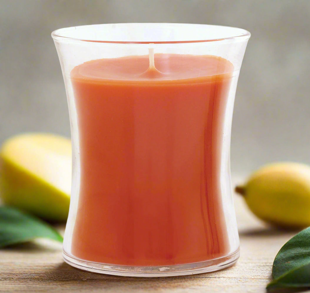 mango cooler candle in a clear elegant glass container on a white background
