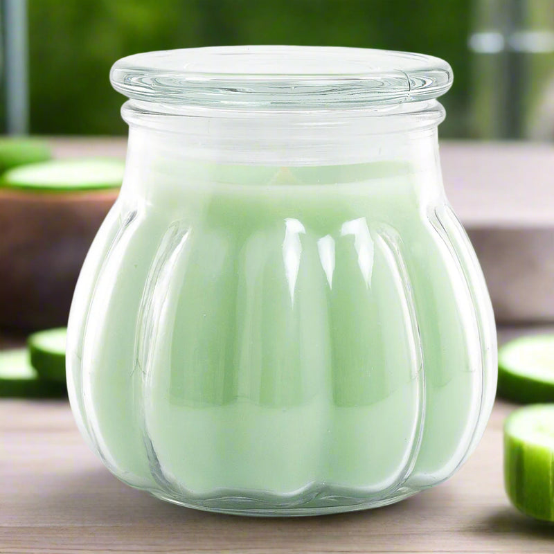 green Contempo candle with a cucumber melon scent, housed in a clear glass jar.